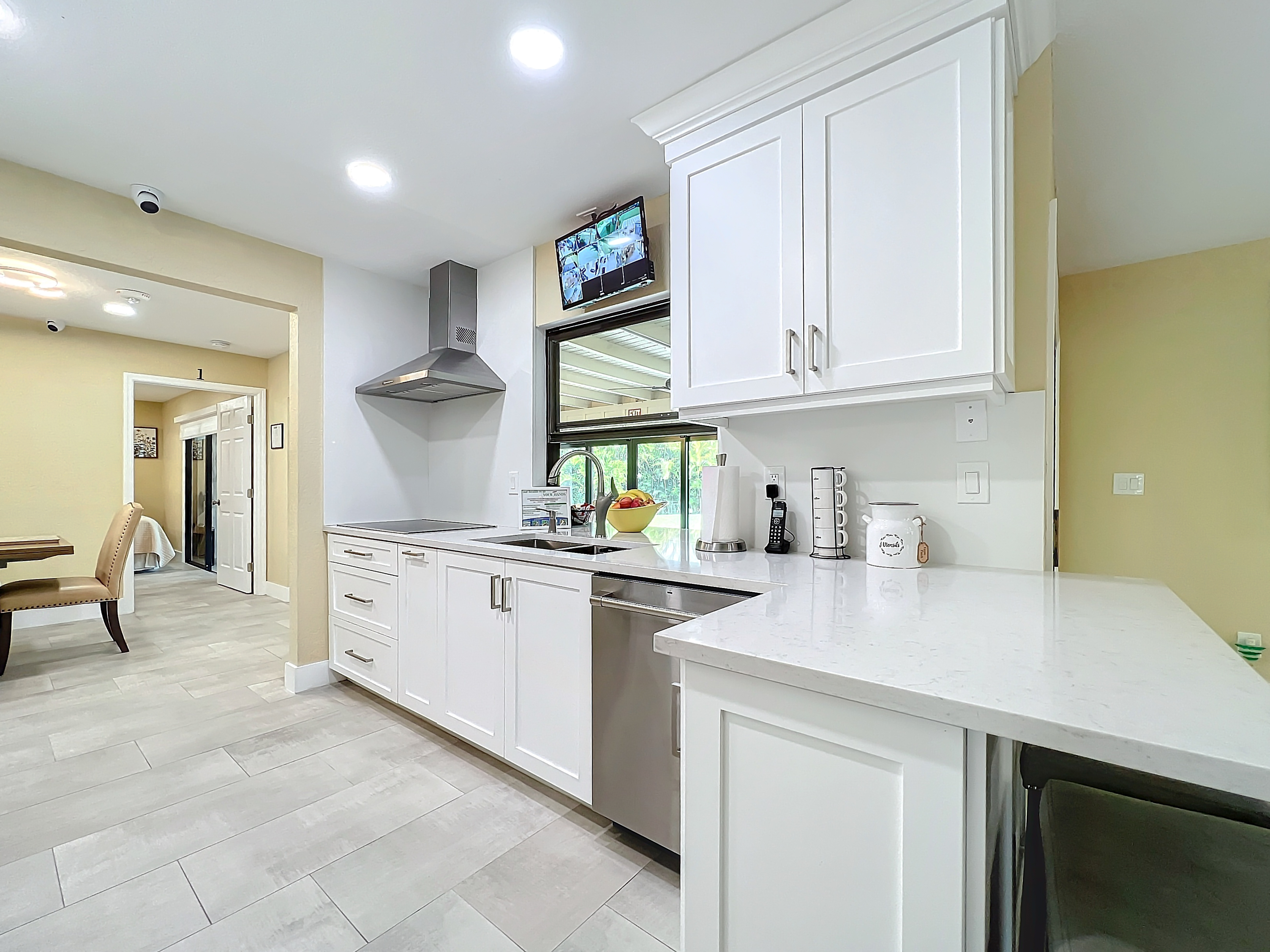 Well-lit modern kitchen workspace showing stove, range hood, and countertops at Abundant Care Residence in Wellington, FL