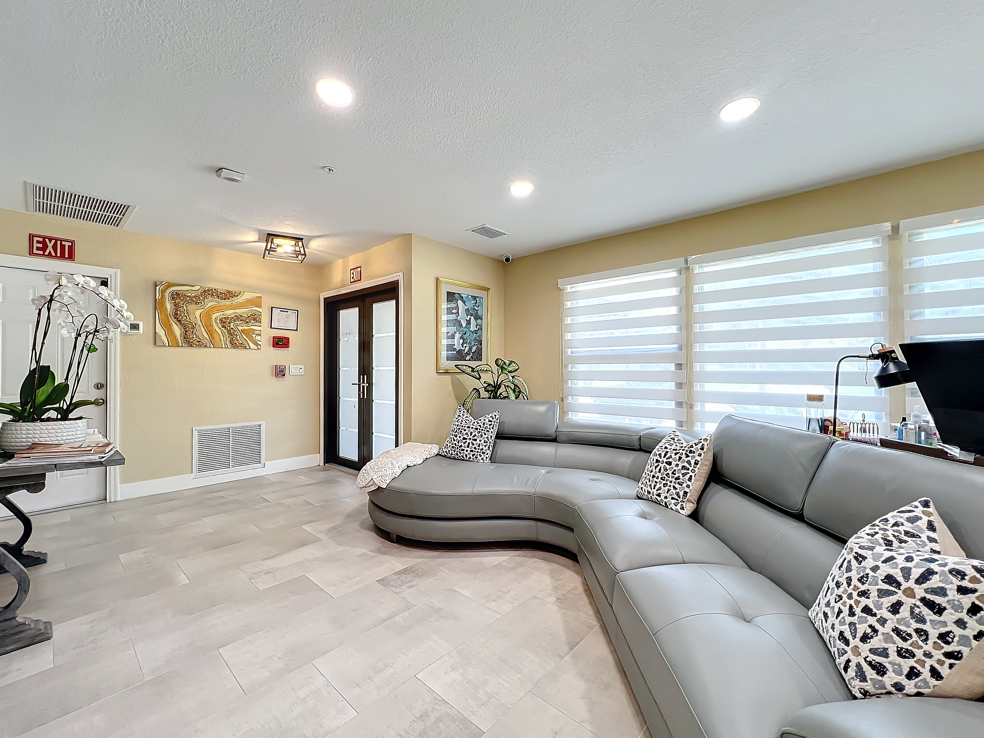 Inviting resident lounge area with modern leather seating and decorative art at Abundant Care Residence in Wellington, FL